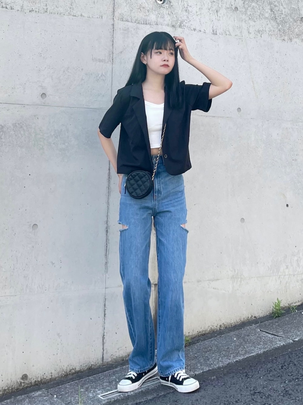 ブラック系のテーラードジャケット、ホワイト系のタンクトップ、ブラック系のショルダーバッグを着用したレディースの夏コーディネートの2枚目の写真