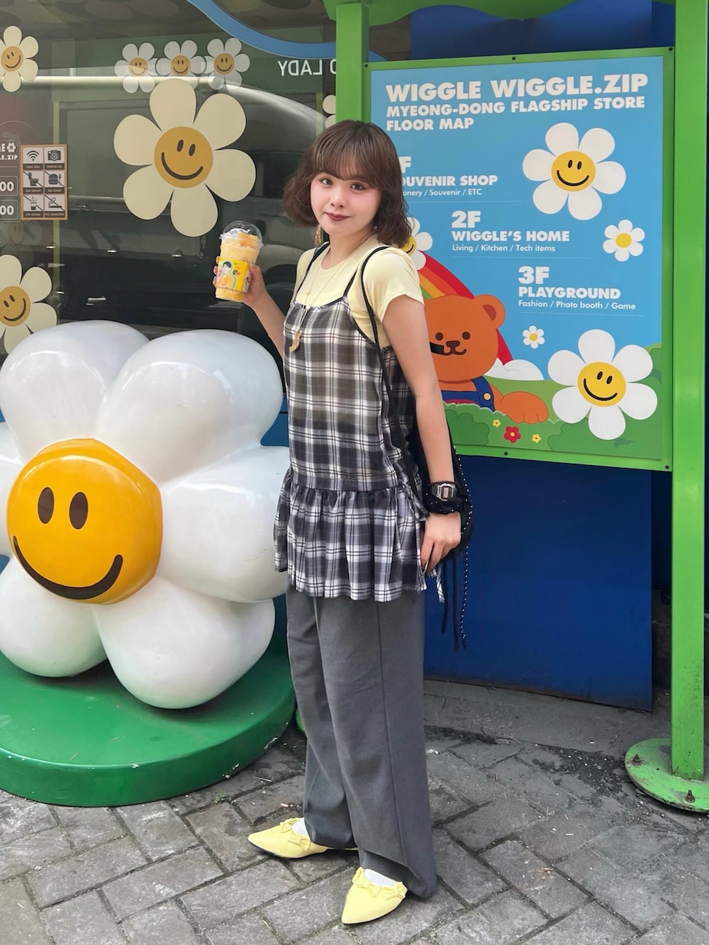 イエロー系のTシャツ/カットソー、ブラック系のバックパック/リュック、イエロー系のパンプスを着用したレディースの夏コーディネートの2枚目の写真