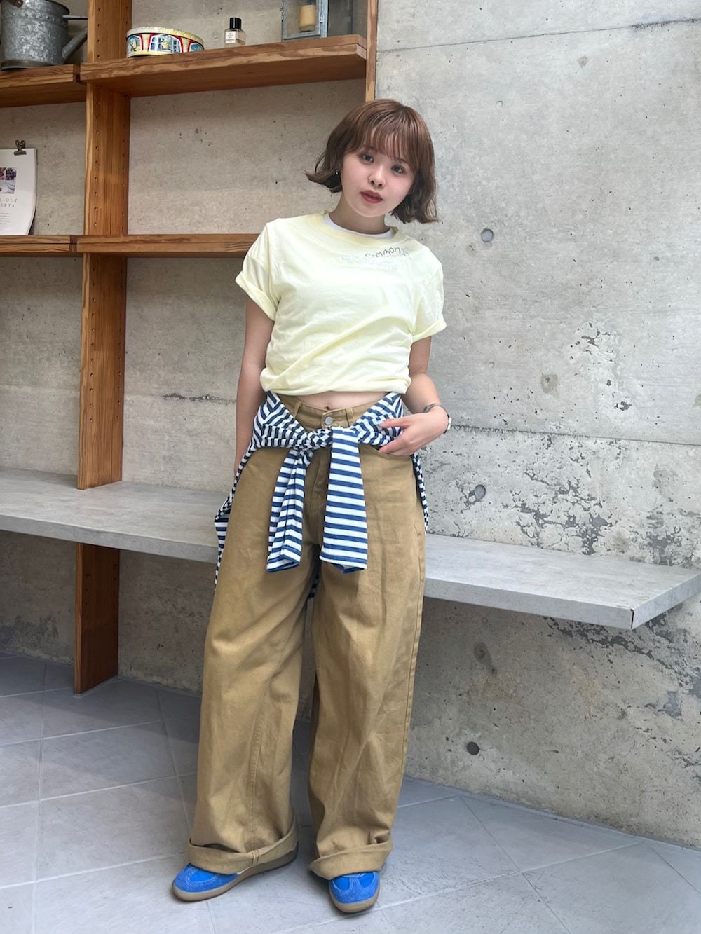 イエロー系のTシャツ/カットソー、ブルー系のTシャツ/カットソー、ベージュ系のデニムパンツを着用したレディースの夏コーディネートの2枚目の写真