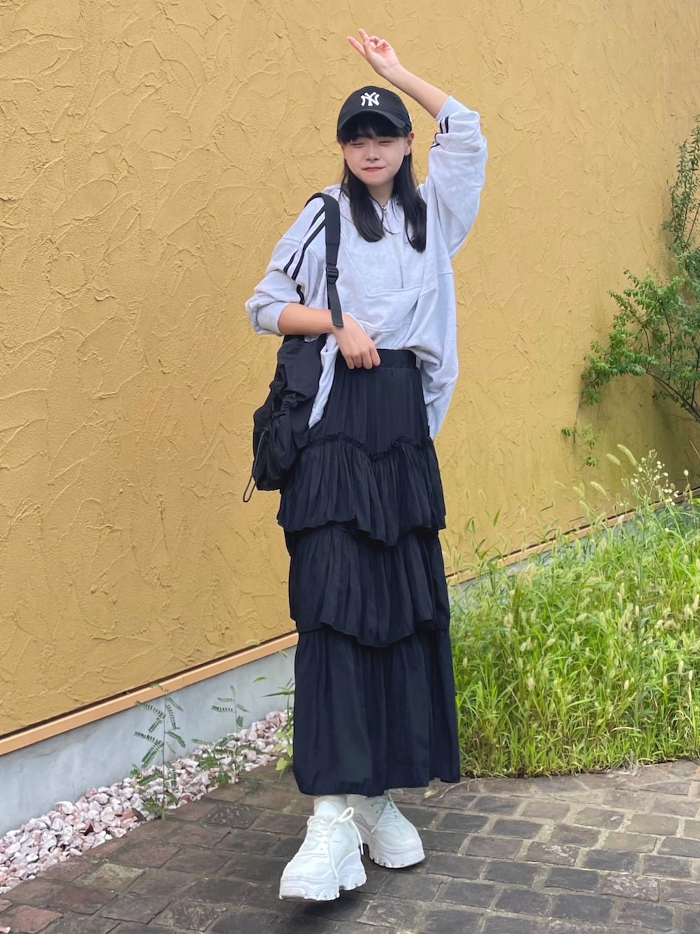 グレー系のパーカー、ブラック系のスカート、ブラック系のバックパック/リュックを着用したレディースの秋コーディネートの2枚目の写真