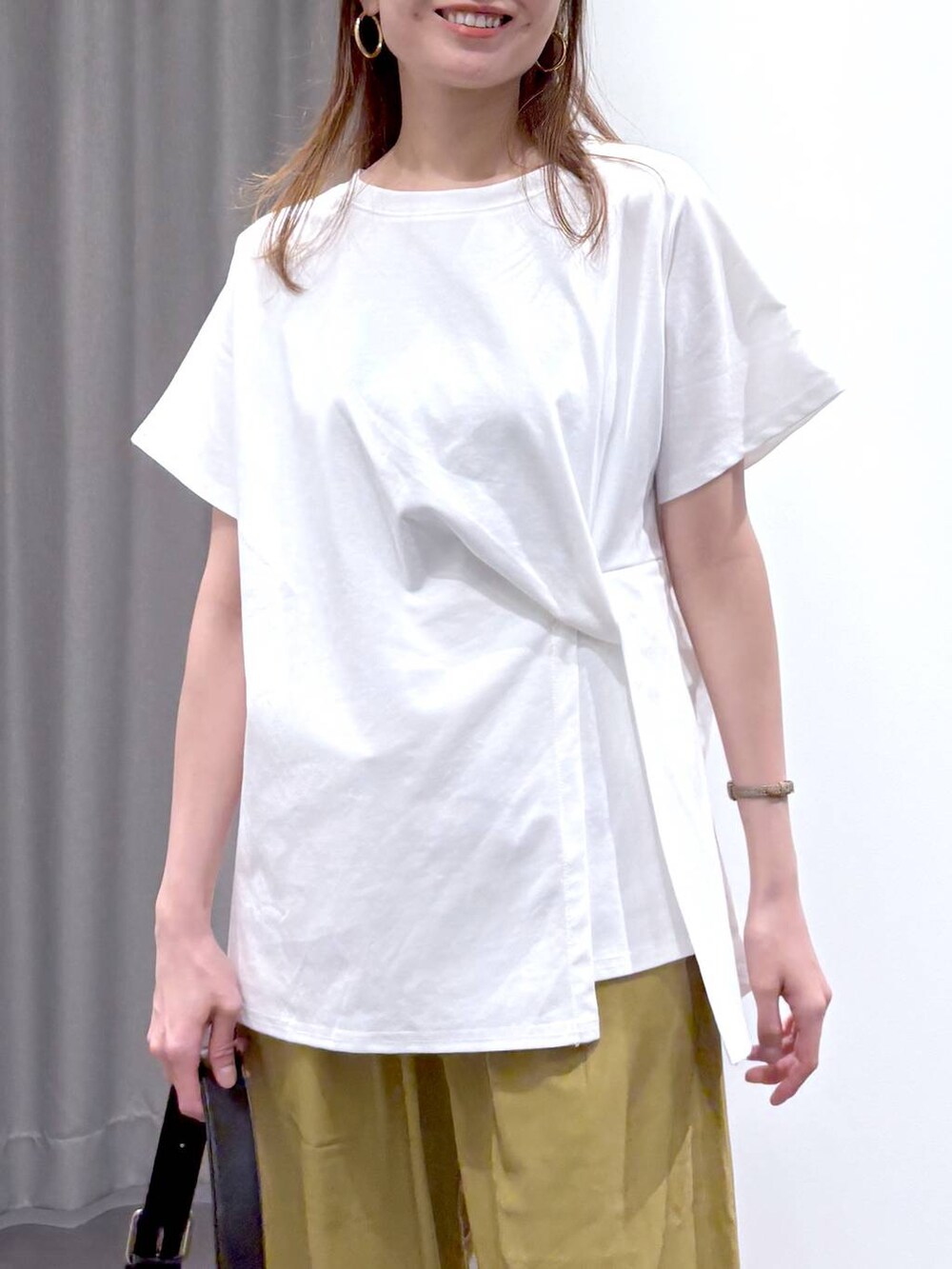 シルバー系のパンプス、ブラック系のショルダーバッグ、ホワイト系のTシャツ/カットソーを着用したレディースの夏コーディネートの5枚目の写真