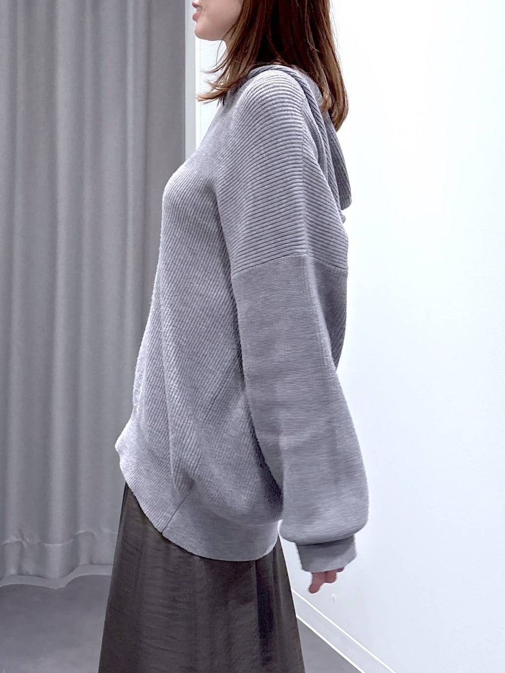 グレー系のスカート、グレー系のニット/セーター、ブラック系のショルダーバッグを着用したレディースの秋コーディネートの6枚目の写真