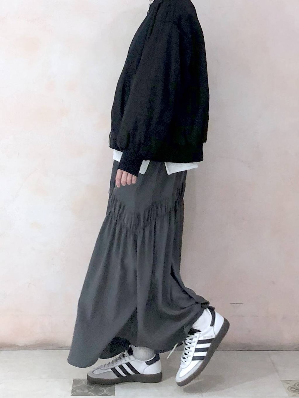 ブラック系のMA-1、ベージュ系のスウェット、グレー系のスカートを着用したレディースの冬コーディネートの8枚目の写真