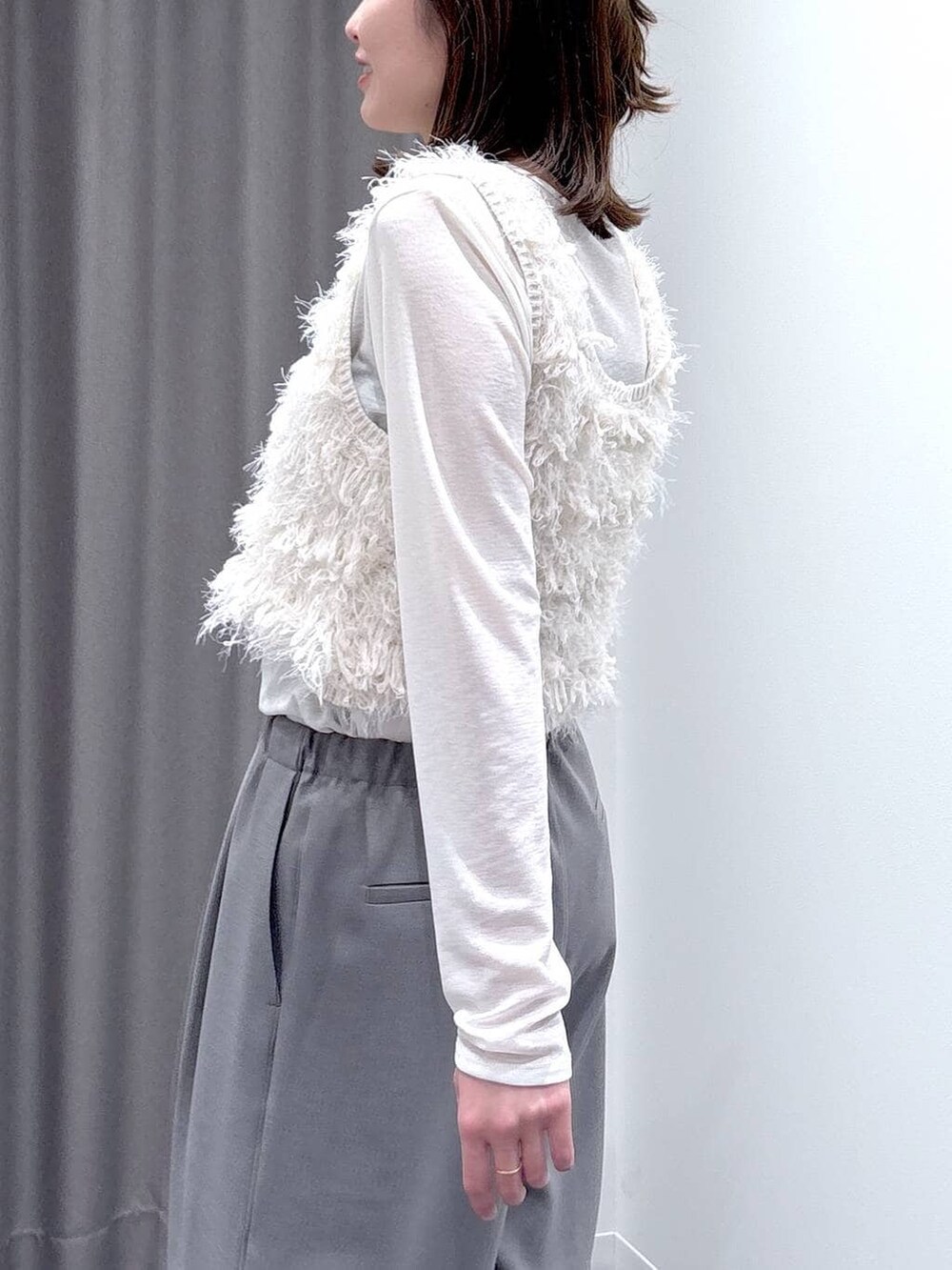 ホワイト系のTシャツ/カットソー、ホワイト系のベスト、ホワイト系のショルダーバッグを着用したレディースの冬コーディネートの6枚目の写真