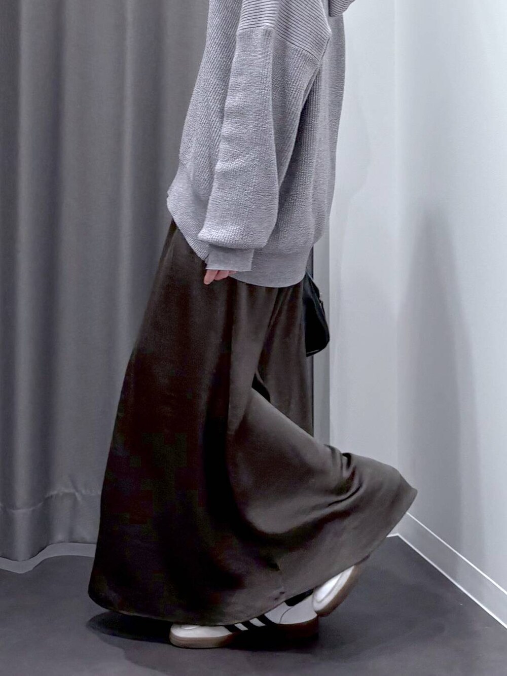 グレー系のスカート、グレー系のニット/セーター、ブラック系のショルダーバッグを着用したレディースの秋コーディネートの8枚目の写真