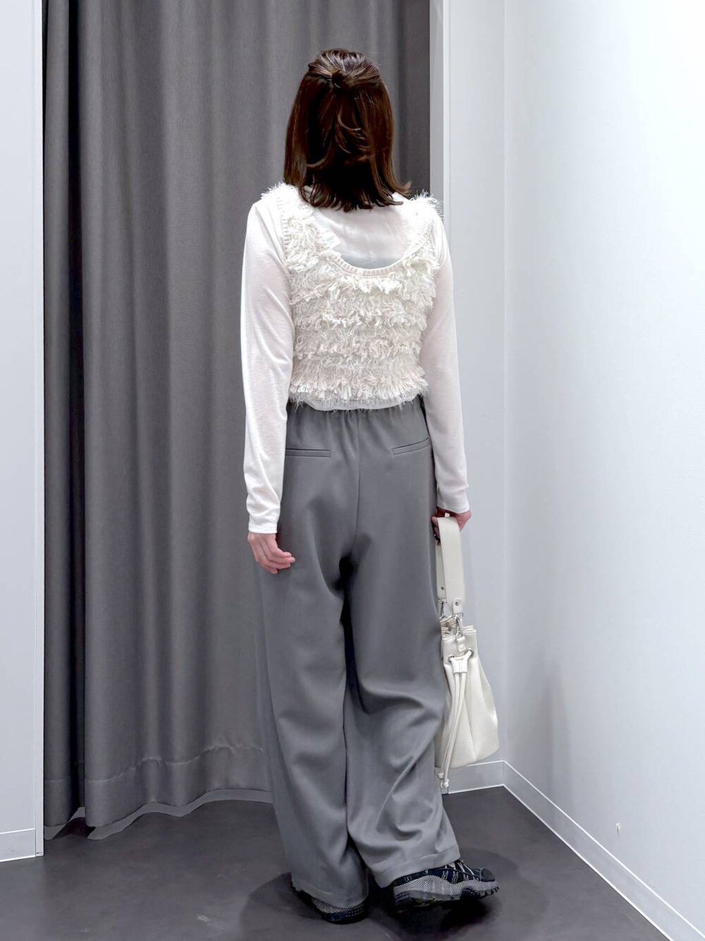 ホワイト系のTシャツ/カットソー、ホワイト系のベスト、ホワイト系のショルダーバッグを着用したレディースの冬コーディネートの4枚目の写真