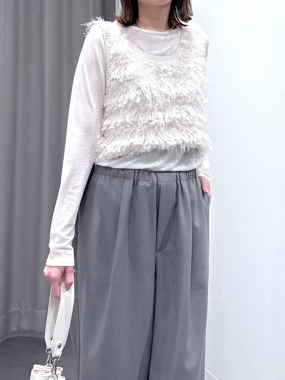 ホワイト系のTシャツ/カットソー、ホワイト系のベスト、ホワイト系のショルダーバッグを着用したレディースの冬コーディネートの5枚目の写真