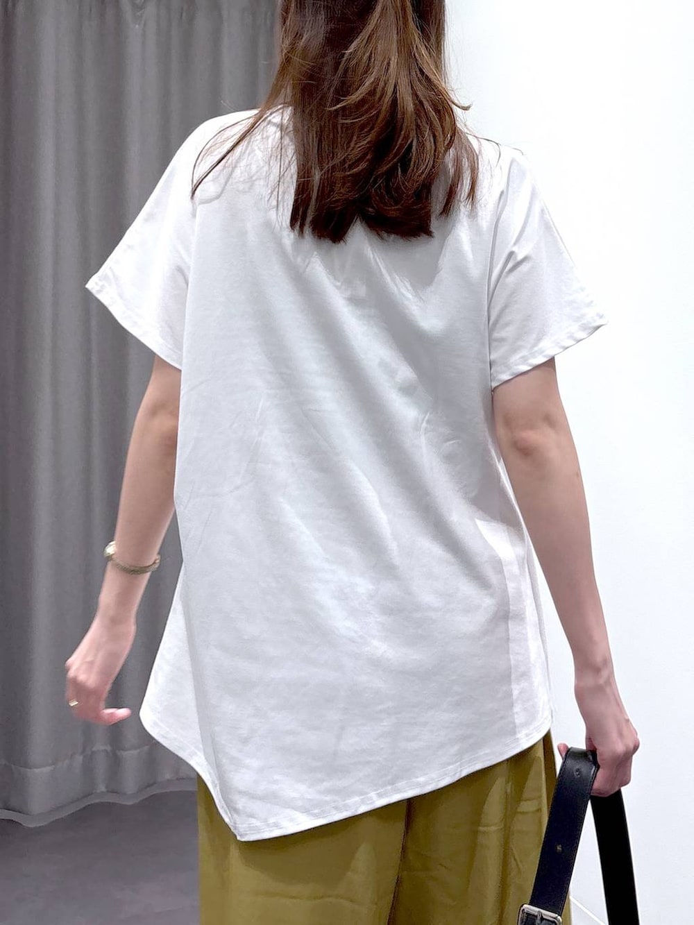 シルバー系のパンプス、ブラック系のショルダーバッグ、ホワイト系のTシャツ/カットソーを着用したレディースの夏コーディネートの7枚目の写真
