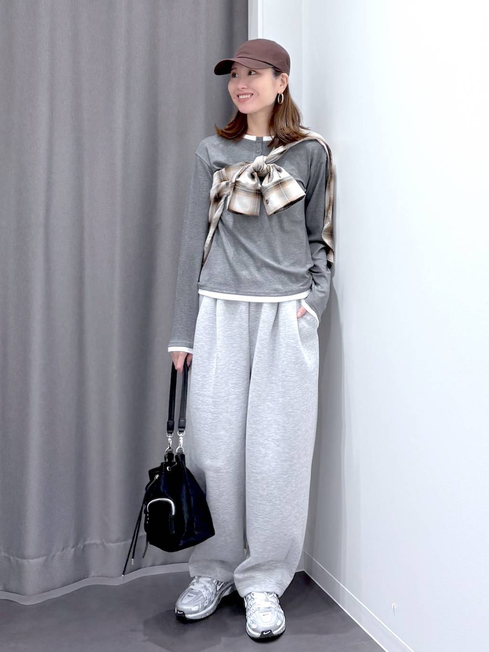 ブラック系のショルダーバッグ、ブラウン系のシャツ/ブラウス、グレー系のスウェットパンツを着用したレディースの秋コーディネートの2枚目の写真