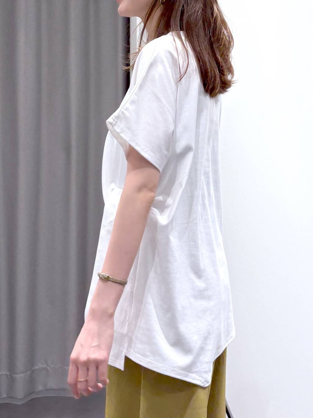 シルバー系のパンプス、ブラック系のショルダーバッグ、ホワイト系のTシャツ/カットソーを着用したレディースの夏コーディネートの6枚目の写真