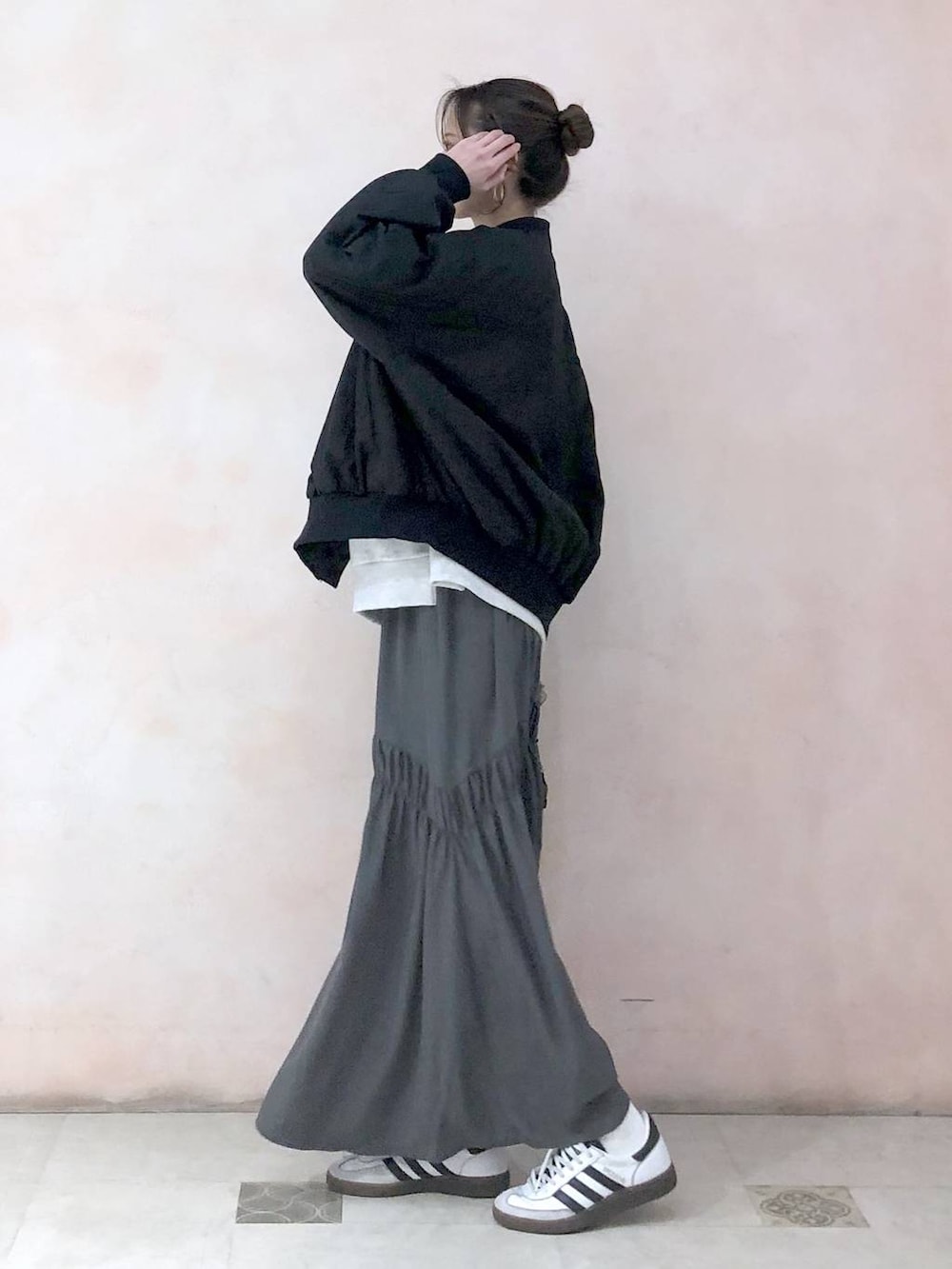 ブラック系のMA-1、ベージュ系のスウェット、グレー系のスカートを着用したレディースの冬コーディネートの3枚目の写真