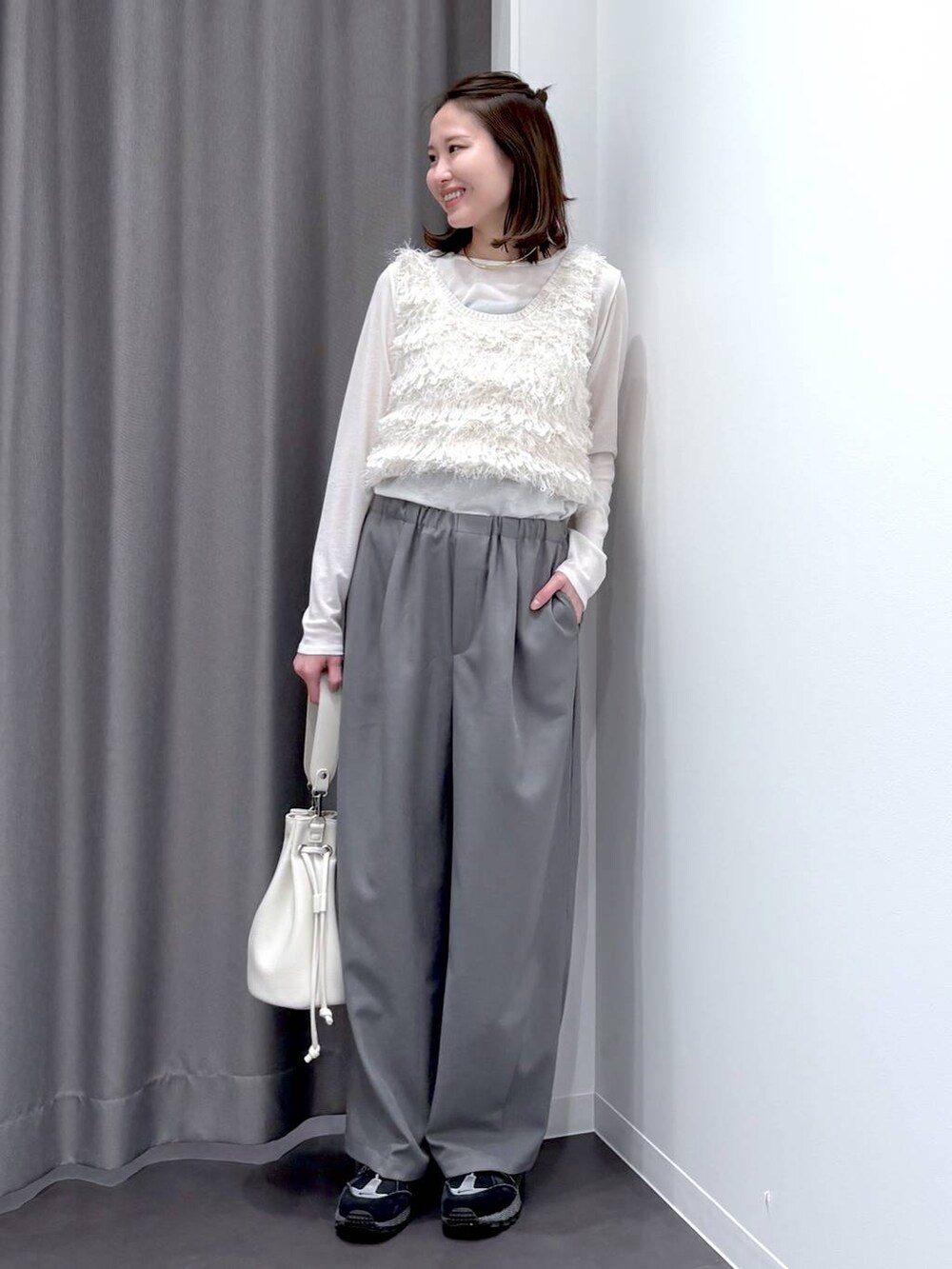 ホワイト系のTシャツ/カットソー、ホワイト系のベスト、ホワイト系のショルダーバッグを着用したレディースの冬コーディネートの2枚目の写真