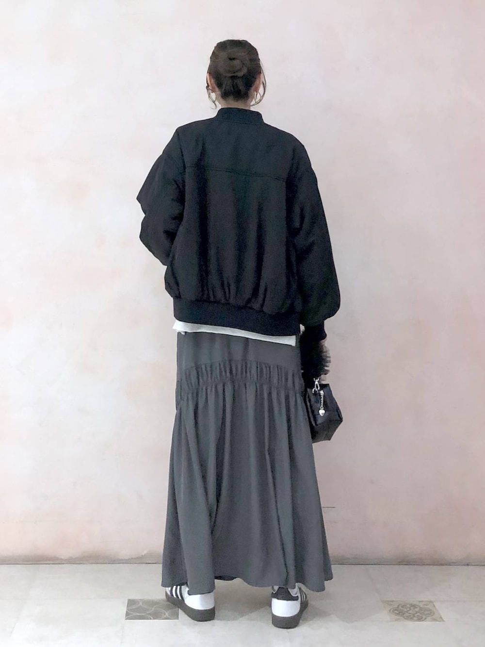 ブラック系のMA-1、ベージュ系のスウェット、グレー系のスカートを着用したレディースの冬コーディネートの4枚目の写真