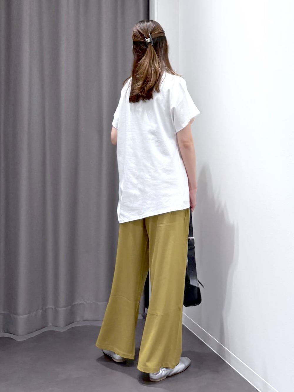 シルバー系のパンプス、ブラック系のショルダーバッグ、ホワイト系のTシャツ/カットソーを着用したレディースの夏コーディネートの4枚目の写真