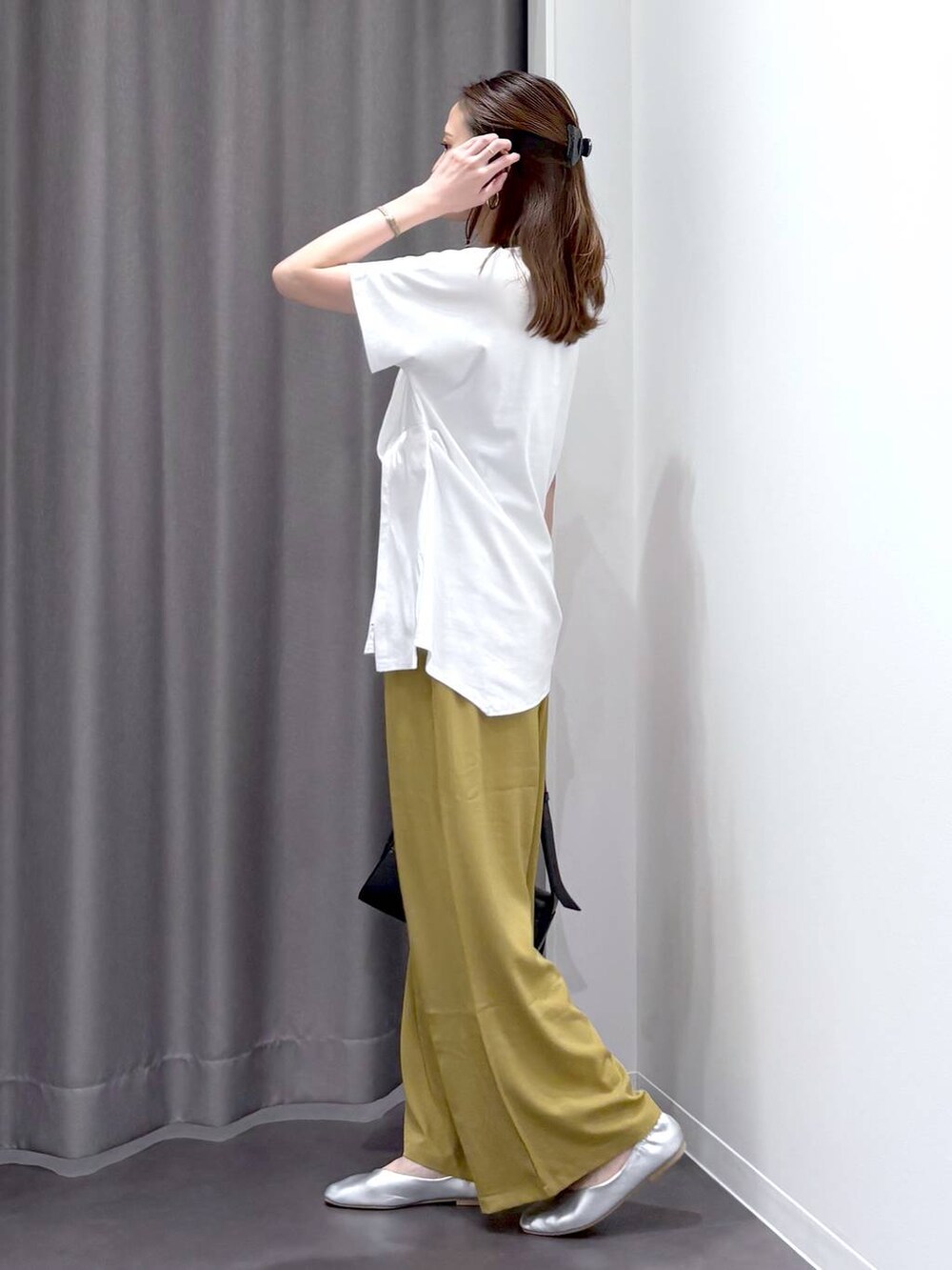 シルバー系のパンプス、ブラック系のショルダーバッグ、ホワイト系のTシャツ/カットソーを着用したレディースの夏コーディネートの3枚目の写真