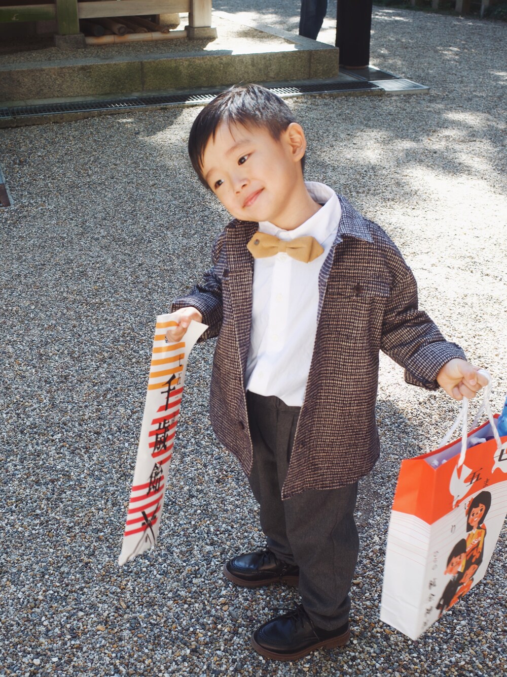 グレー系のジャケット/アウター、ブラック系のシューズを着用したキッズの冬コーディネートの2枚目の写真