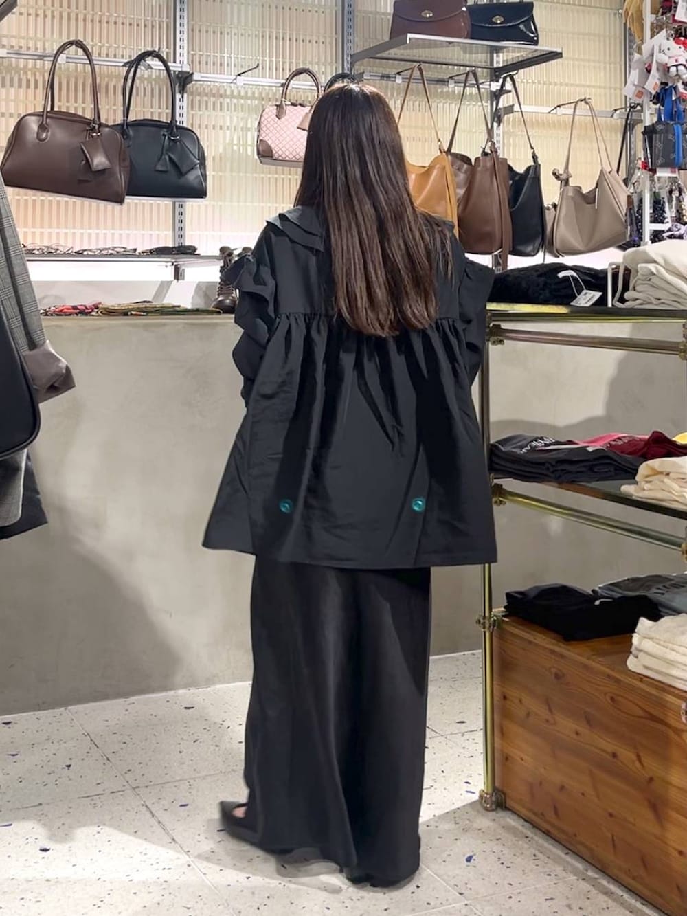 ブラック系のスカート、ブラウン系のショルダーバッグ、ブラック系のパンプスを着用したレディースの秋コーディネートの4枚目の写真