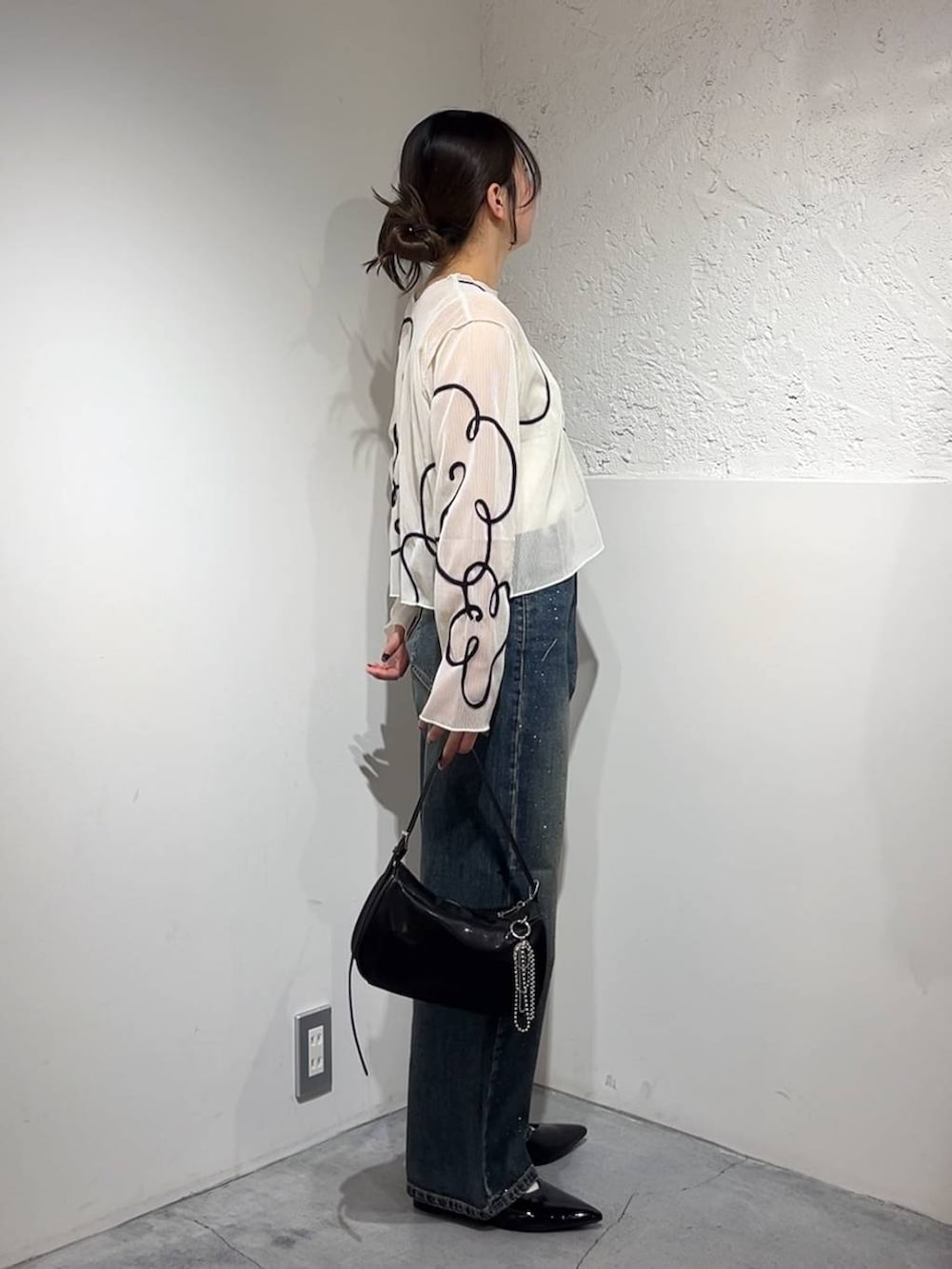 ブルー系のデニムパンツ、シルバー系のトートバッグ、シルバー系のパンプスを着用したレディースの春コーディネートの3枚目の写真