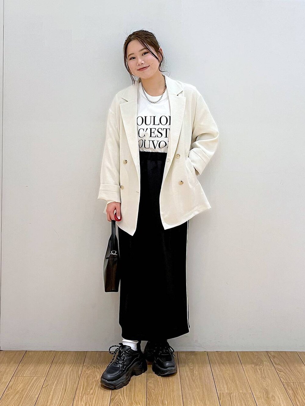 ホワイト系のテーラードジャケット、ホワイト系のTシャツ/カットソー、ブラック系のスニーカーを着用したレディースの春コーディネートの2枚目の写真