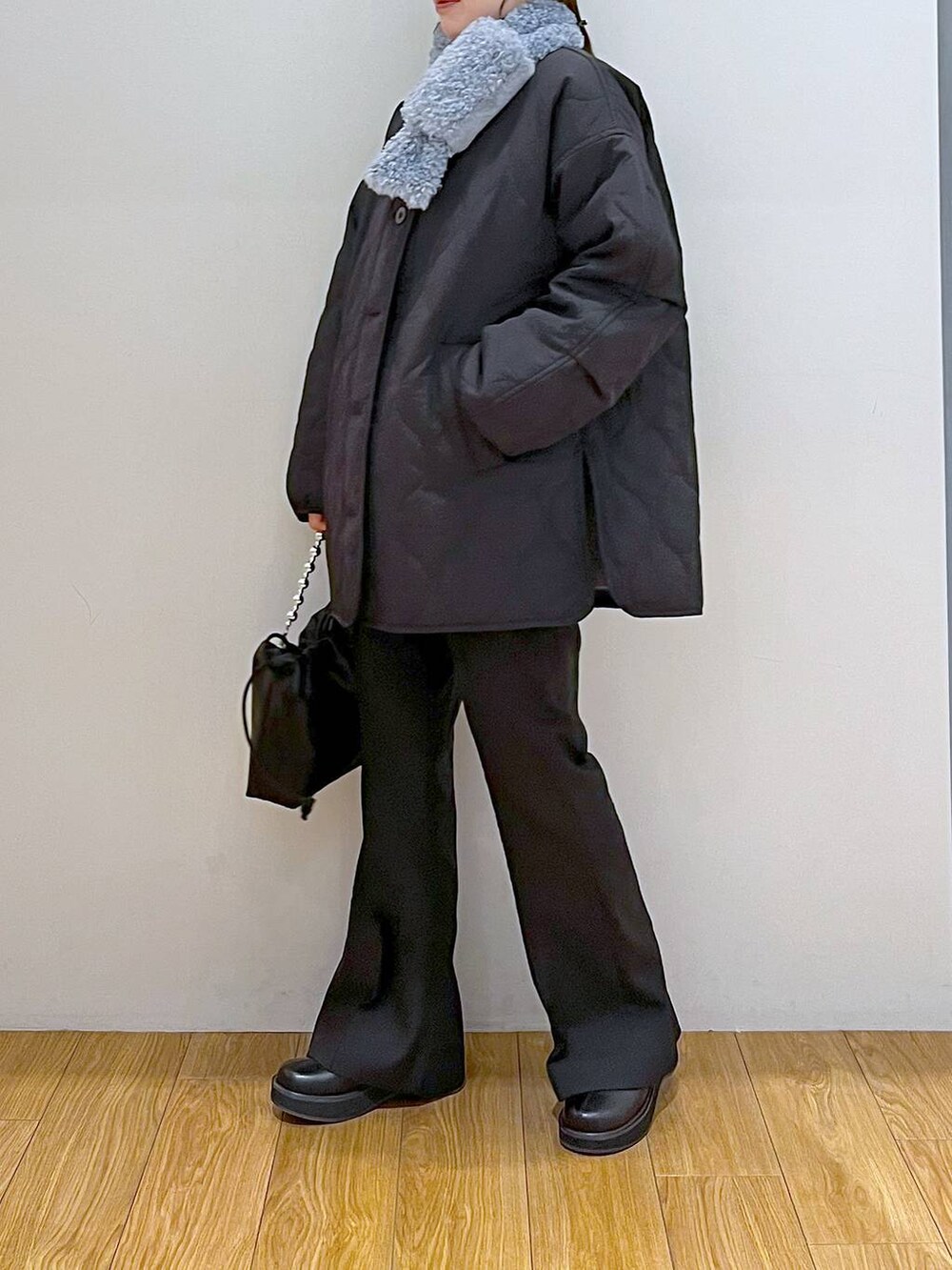 ブラック系のブルゾン、ブラック系のブーツ、ブラック系のスラックスを着用したレディースの冬コーディネートの2枚目の写真