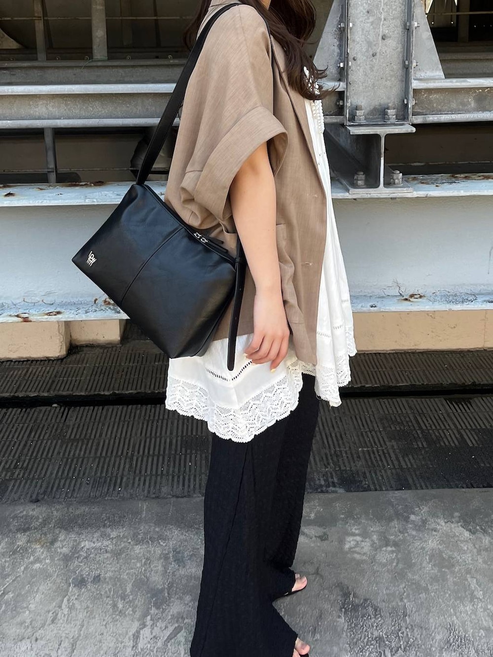 ベージュ系のショルダーバッグ、シルバー系のサンダル、ホワイト系のワンピースを着用したレディースの春コーディネートの3枚目の写真