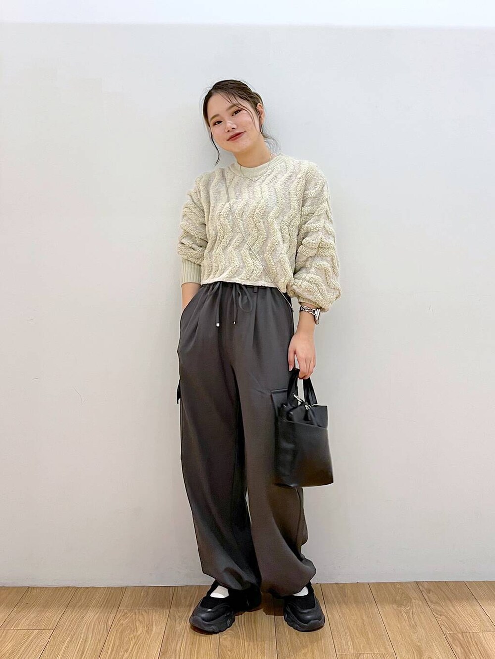 ブラック系のショルダーバッグ、グレー系のその他パンツ、ホワイト系のニット/セーターを着用したレディースの秋コーディネートの2枚目の写真