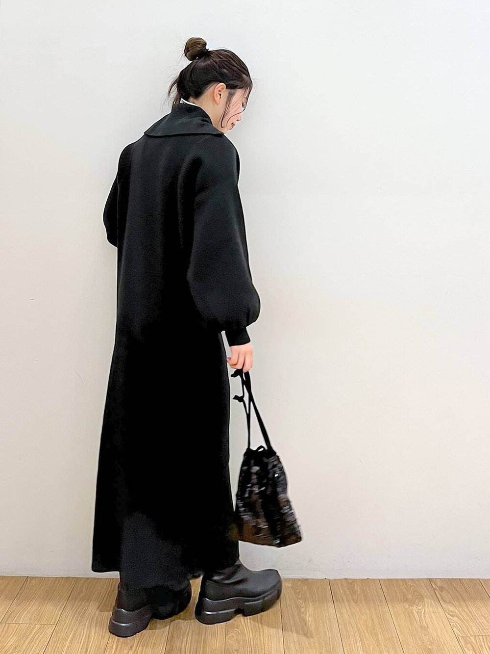 ホワイト系のTシャツ/カットソー、ブラック系のブーツ、ブラック系のハンドバッグを着用したレディースの冬コーディネートの3枚目の写真