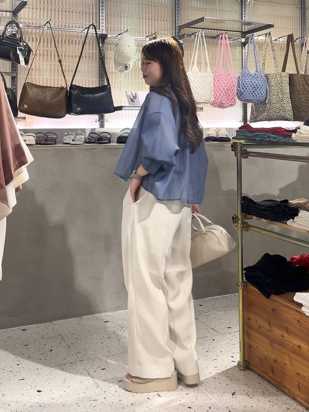 ブルー系のシャツ/ブラウス、ホワイト系のスラックス、ホワイト系のサンダルを着用したレディースの夏コーディネートの3枚目の写真