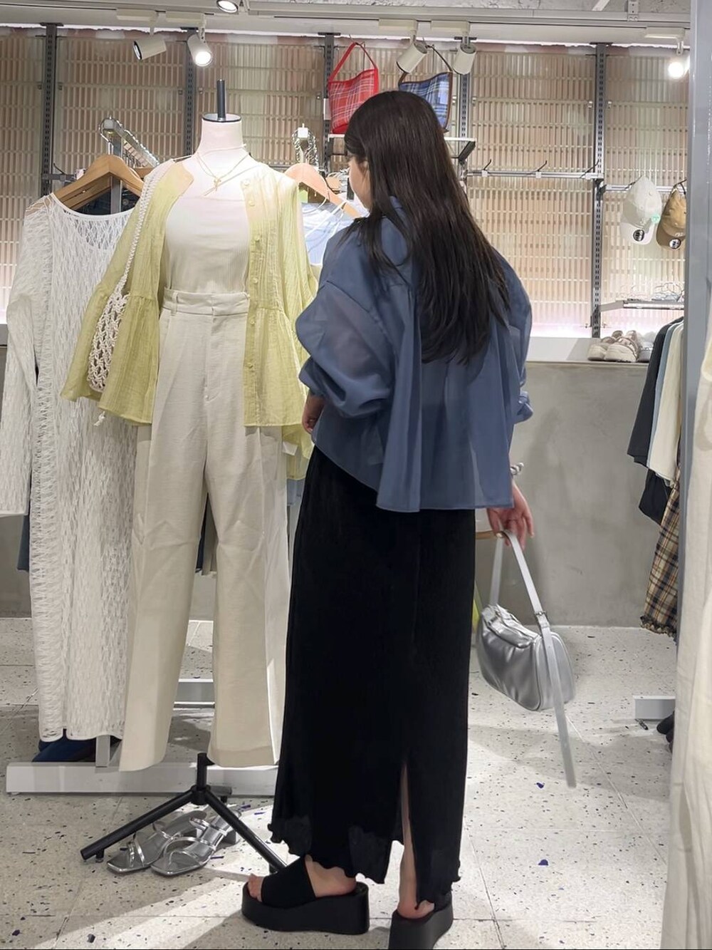 ブルー系のシャツ/ブラウス、ブラック系のサンダル、シルバー系のトートバッグを着用したレディースの春コーディネートの3枚目の写真