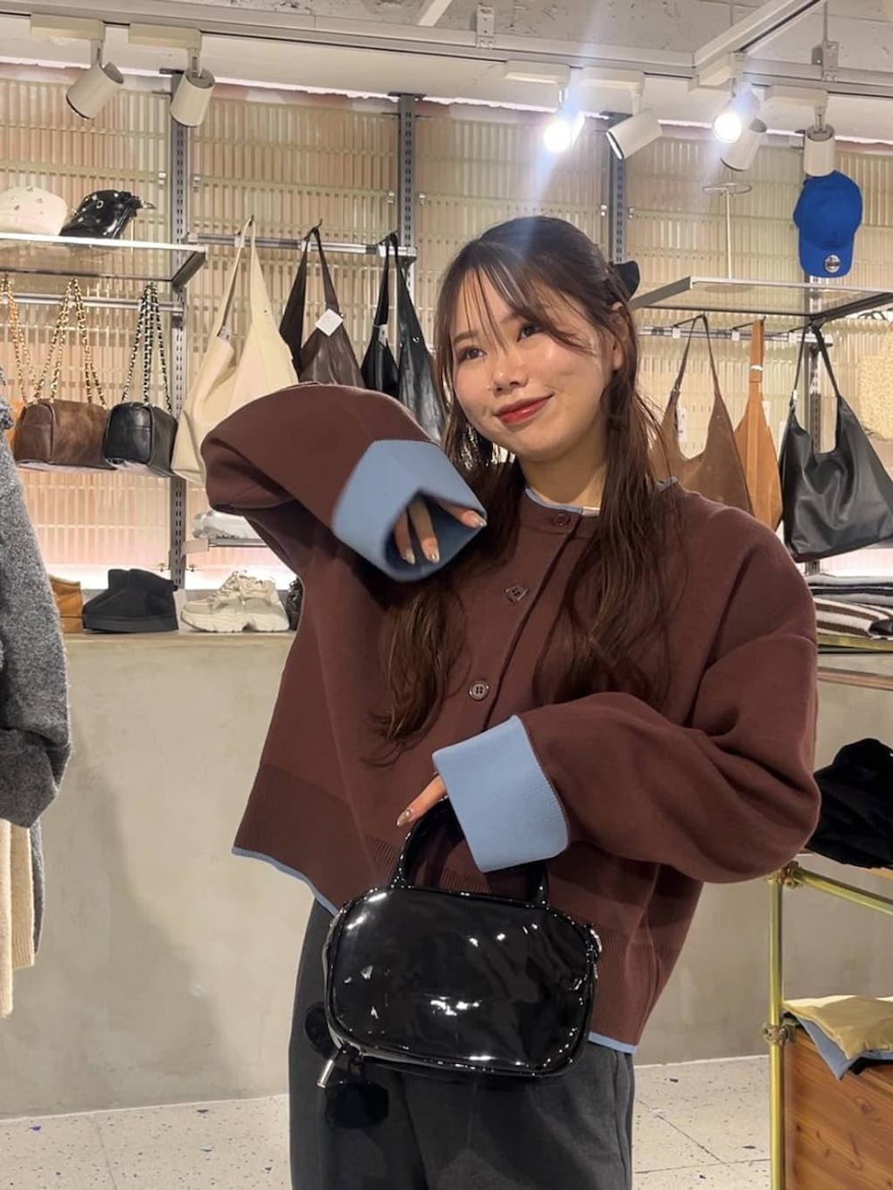 グレー系のスラックス、ブラック系のボストンバッグ、ブラック系のブーツを着用したレディースの冬コーディネートの2枚目の写真