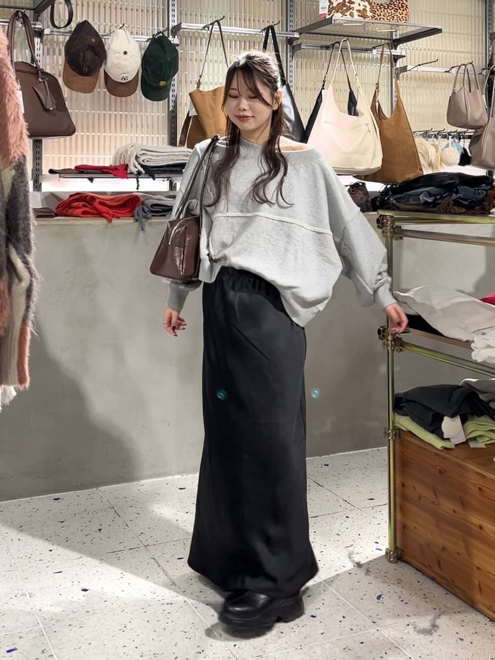 ブラック系のブーツ、グレー系のスウェット、ブラック系のスカートを着用したレディースの秋コーディネートの2枚目の写真