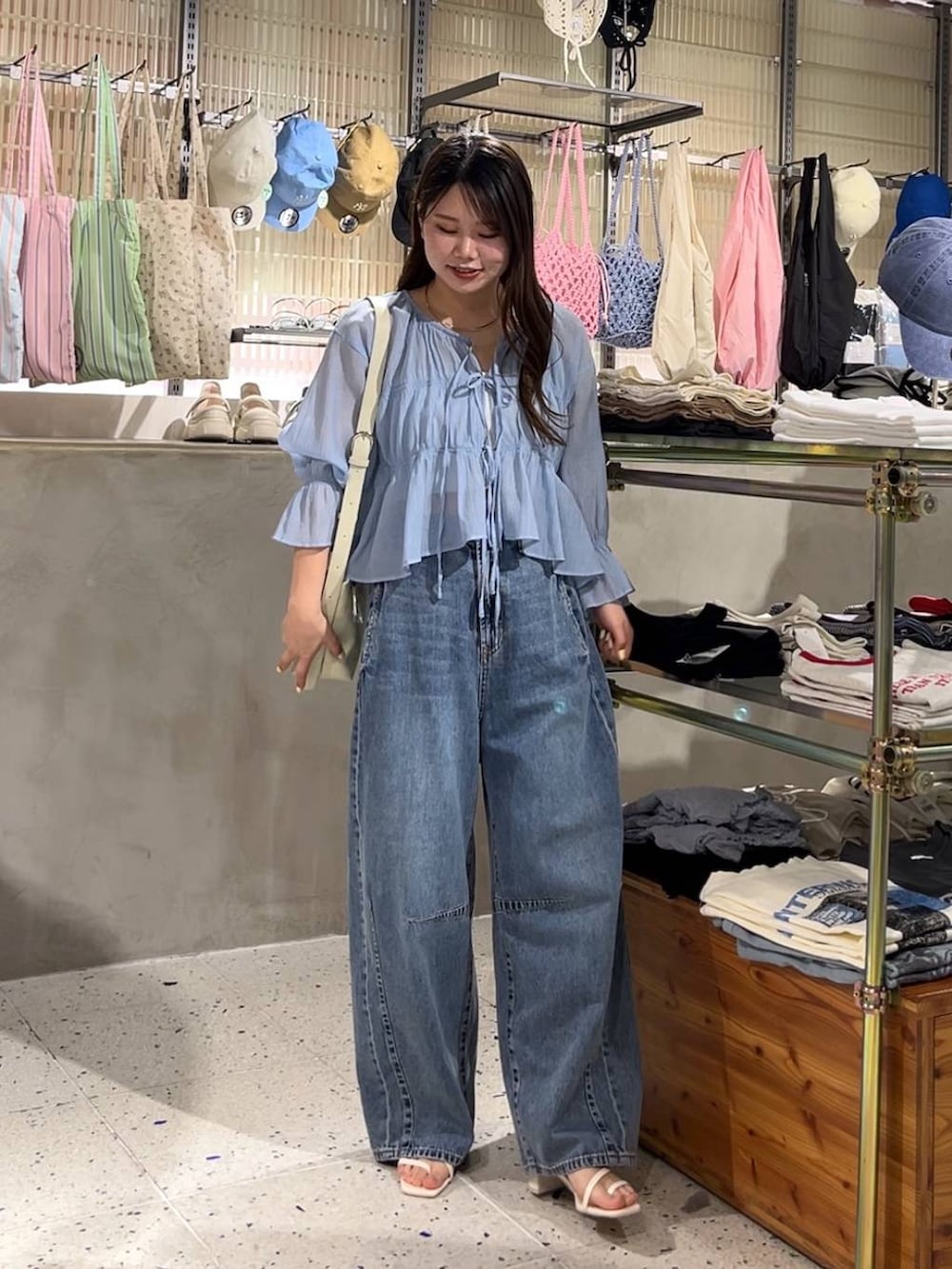 ベージュ系のキャミソール、ブルー系のシャツ/ブラウス、ブルー系のデニムパンツを着用したレディースの春コーディネートの2枚目の写真