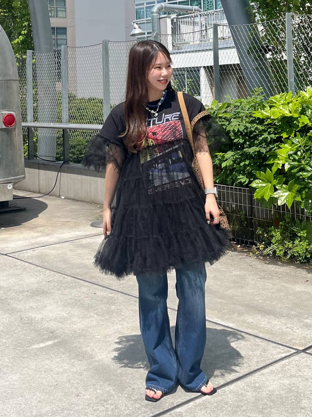 その他のトートバッグ、ブラック系のサンダル、ブルー系のデニムパンツを着用したレディースの春コーディネートの2枚目の写真