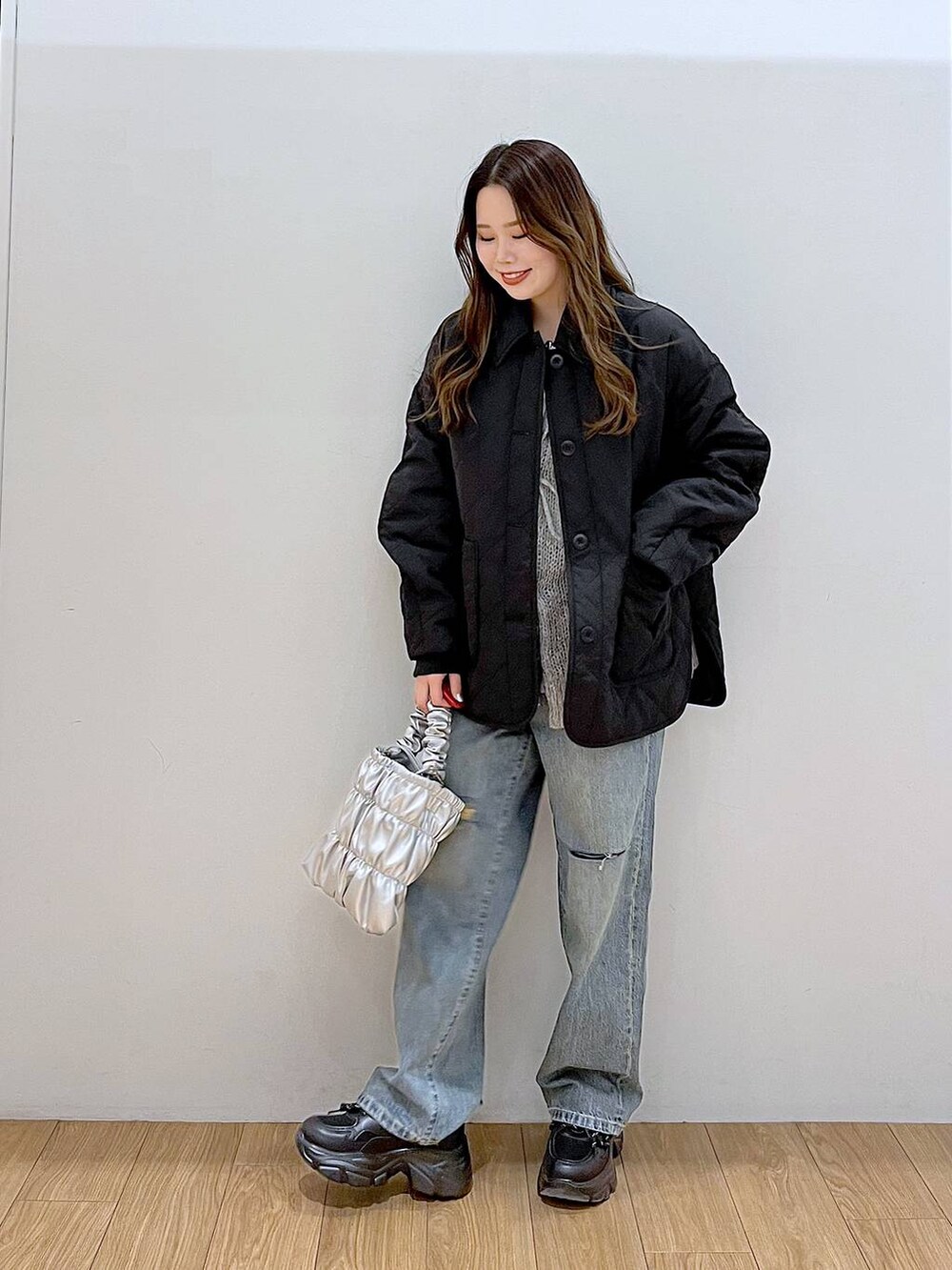 ブラック系のブルゾン、ブルー系のデニムパンツ、ブラック系のスニーカーを着用したレディースの冬コーディネートの3枚目の写真