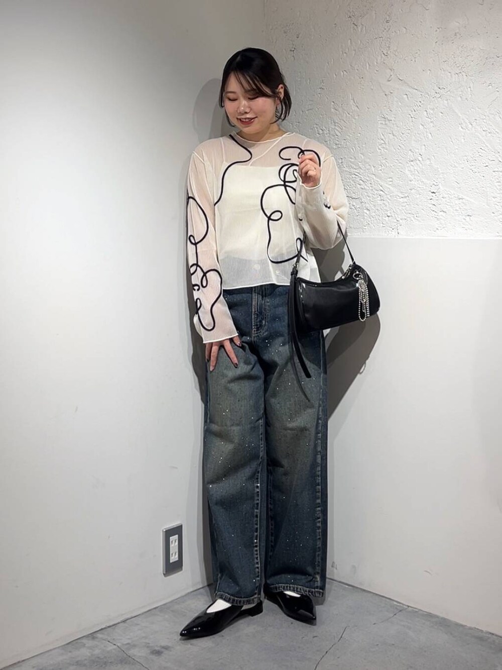 ブルー系のデニムパンツ、シルバー系のトートバッグ、シルバー系のパンプスを着用したレディースの春コーディネートの2枚目の写真