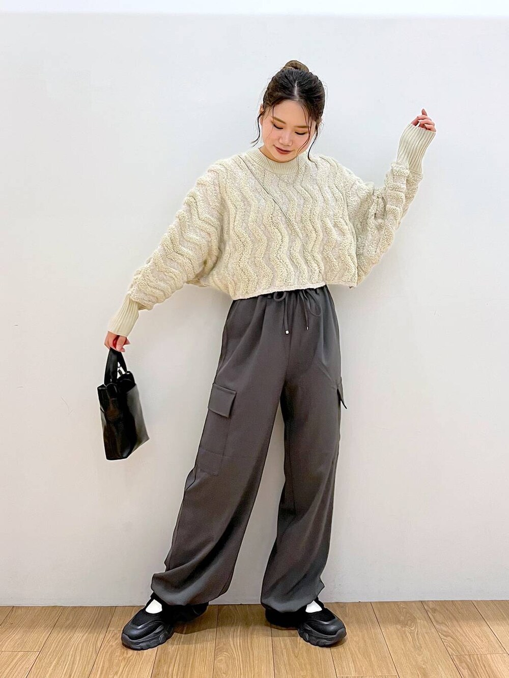 ブラック系のショルダーバッグ、グレー系のその他パンツ、ホワイト系のニット/セーターを着用したレディースの秋コーディネートの4枚目の写真