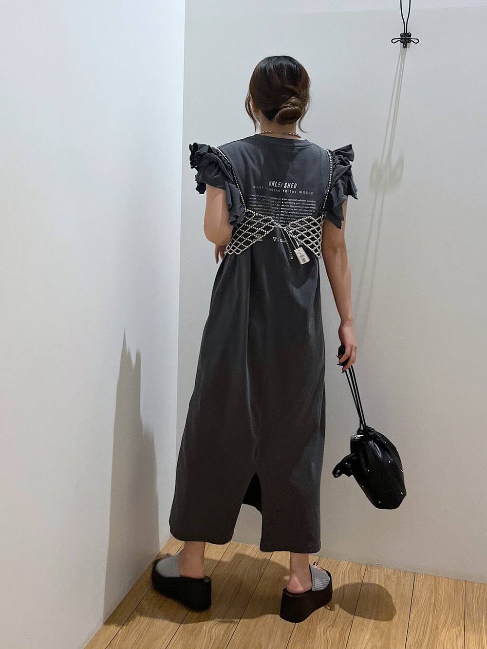 ブラック系のサンダル、ブラック系のショルダーバッグ、シルバー系のベストを着用したレディースの夏コーディネートの7枚目の写真