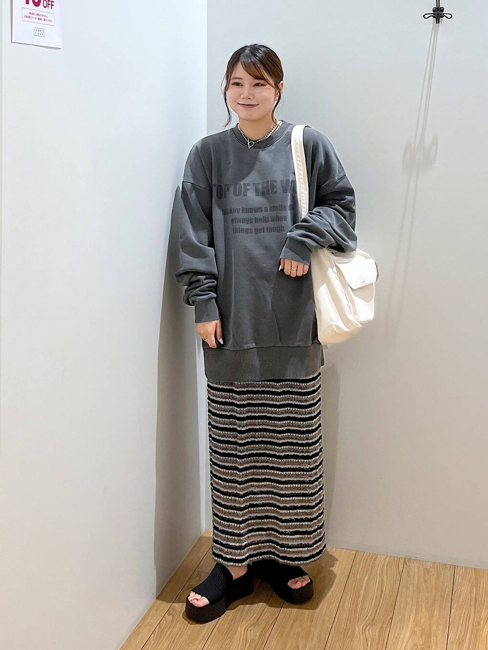 ブラック系のサンダル、ホワイト系のショルダーバッグ、ブラック系のスカートを着用したレディースの夏コーディネートの2枚目の写真