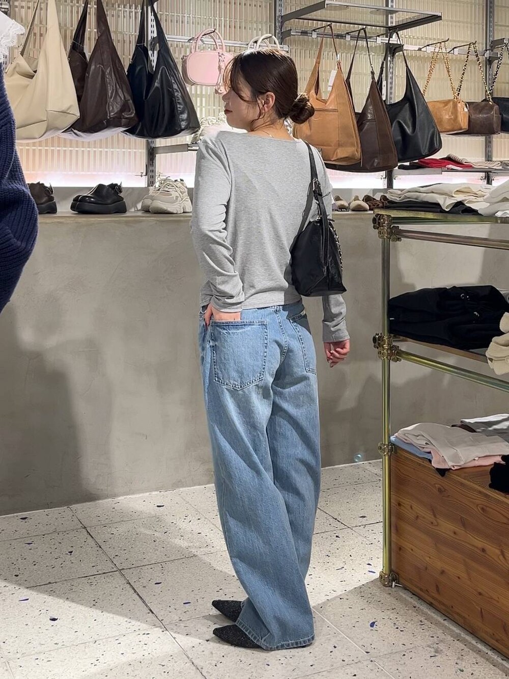 ブルー系のデニムパンツ、ブラック系のショルダーバッグ、ブラック系のパンプスを着用したレディースの冬コーディネートの5枚目の写真