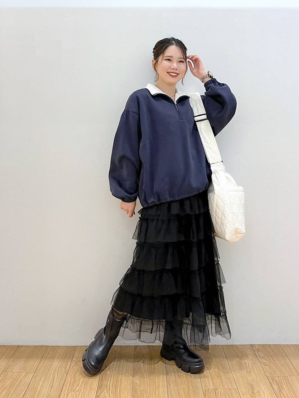 ブラック系のブーツ、ブルー系のスウェット、ブラック系のスカートを着用したレディースの秋コーディネートの3枚目の写真