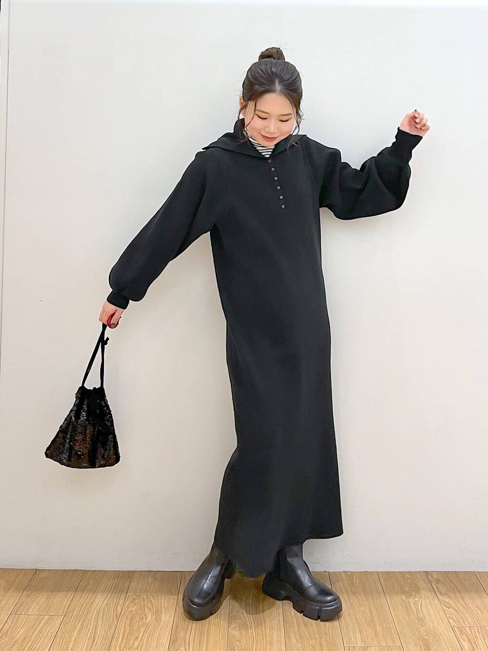 ホワイト系のTシャツ/カットソー、ブラック系のブーツ、ブラック系のハンドバッグを着用したレディースの冬コーディネートの2枚目の写真