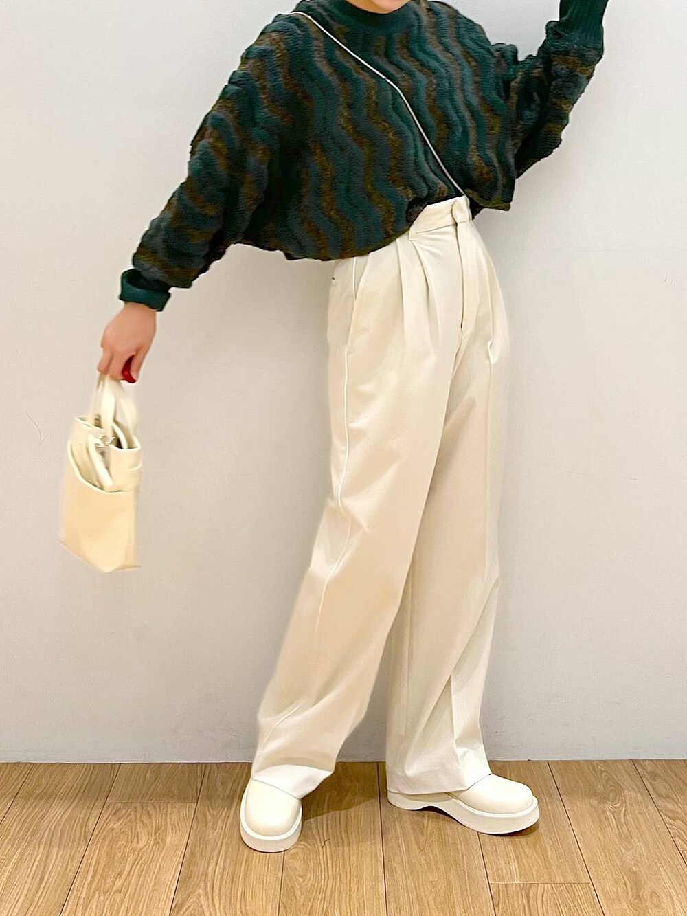 ホワイト系のその他パンツ、ホワイト系のブーツ、グリーン系のニット/セーターを着用したレディースの秋コーディネートの3枚目の写真