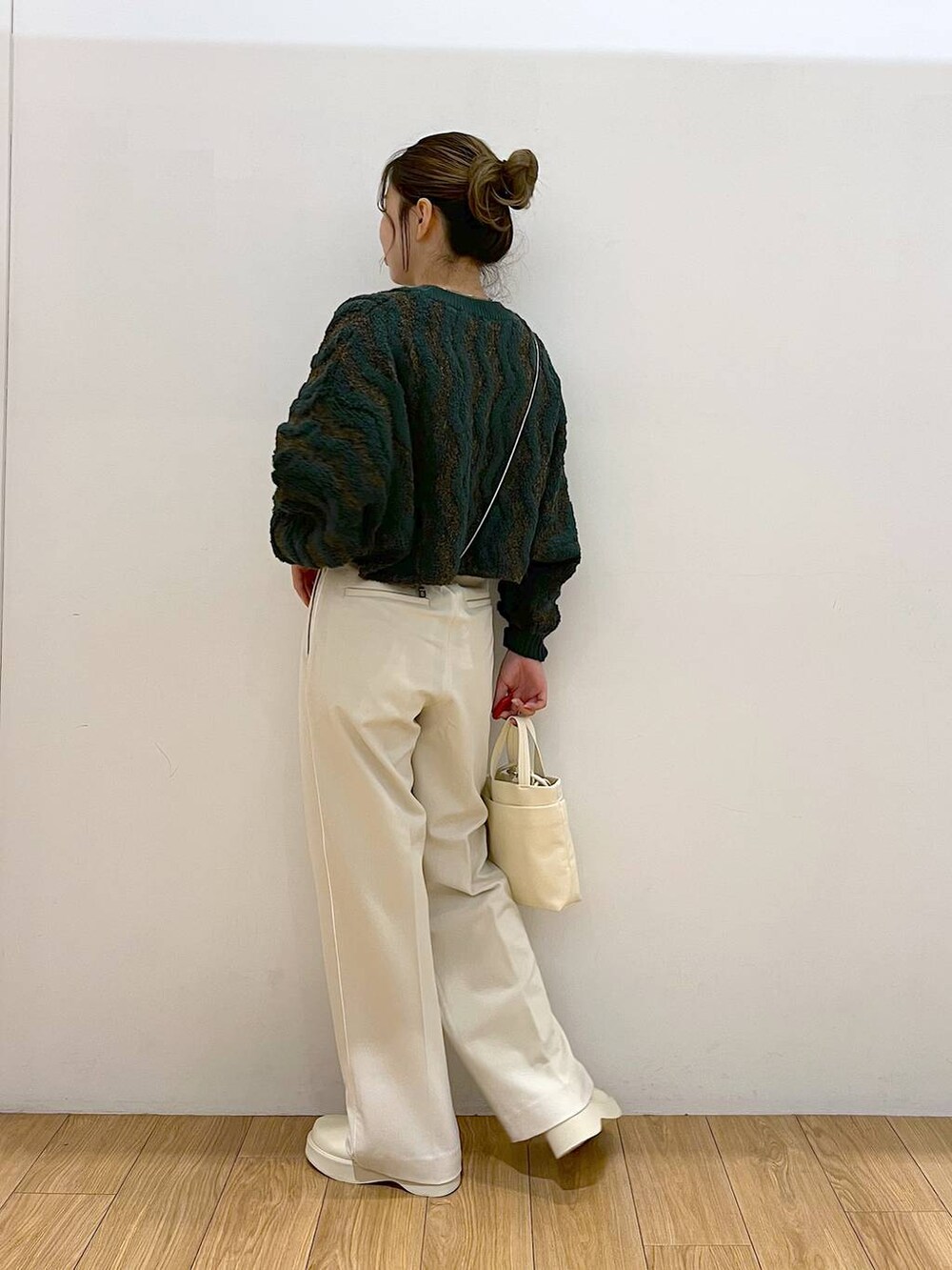 ホワイト系のその他パンツ、ホワイト系のブーツ、グリーン系のニット/セーターを着用したレディースの秋コーディネートの4枚目の写真