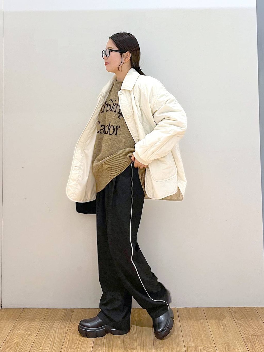 ホワイト系のニット/セーター、ブラック系のブーツ、ブラック系のその他パンツを着用したレディースの冬コーディネートの3枚目の写真