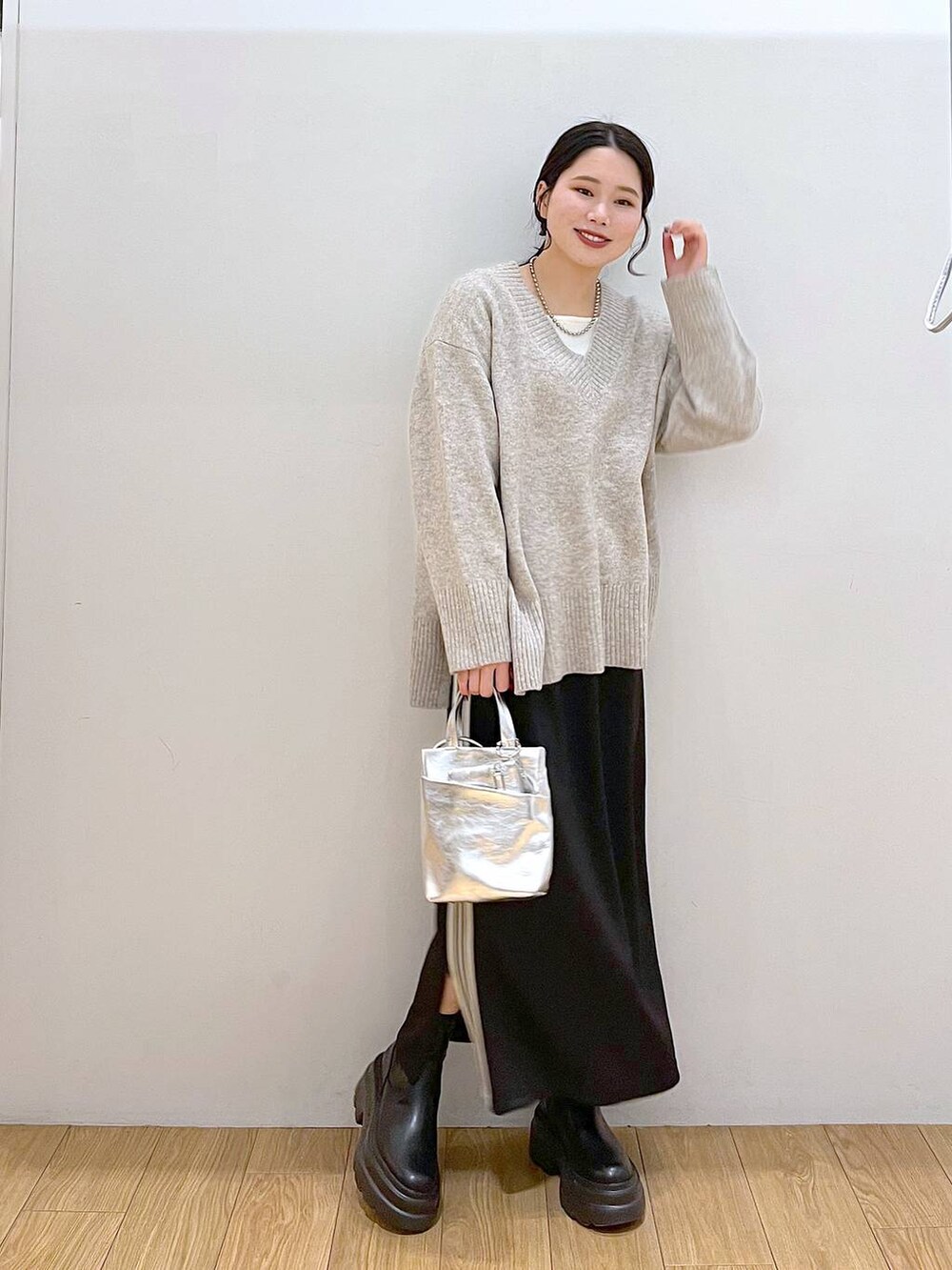 ホワイト系のTシャツ/カットソー、グレー系のニット/セーター、ブラック系のブーツを着用したレディースの冬コーディネートの3枚目の写真