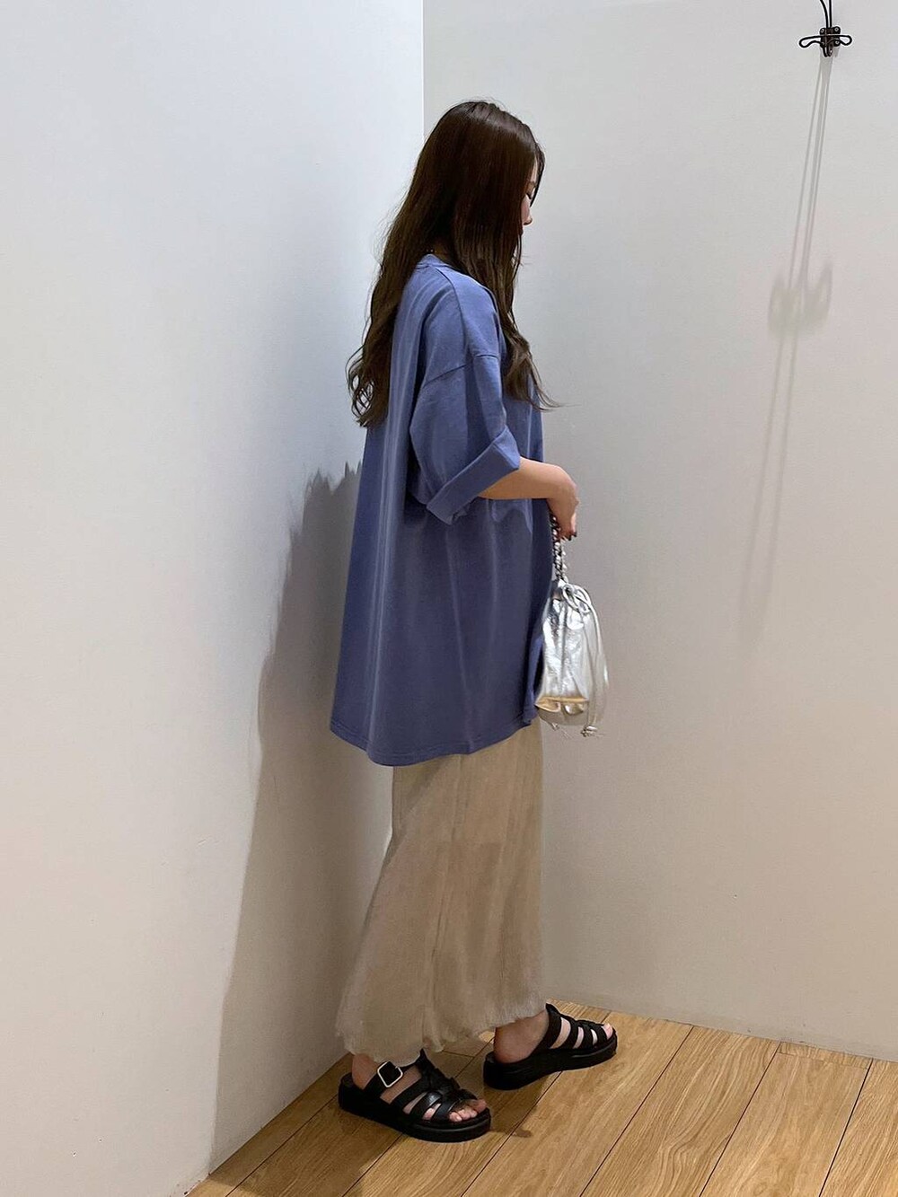 ホワイト系のスカート、ブルー系のTシャツ/カットソー、ブラック系のスニーカーを着用したレディースの夏コーディネートの5枚目の写真