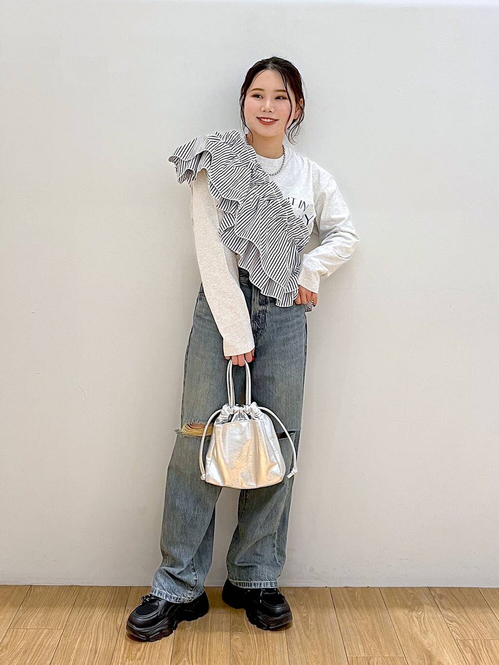 グレー系のTシャツ/カットソー、ブラック系のワンピース、ブルー系のデニムパンツを着用したレディースの春コーディネートの2枚目の写真