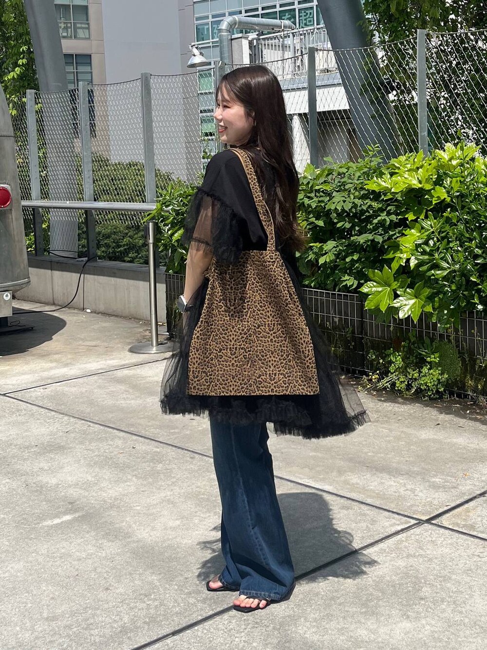 その他のトートバッグ、ブラック系のサンダル、ブルー系のデニムパンツを着用したレディースの春コーディネートの4枚目の写真