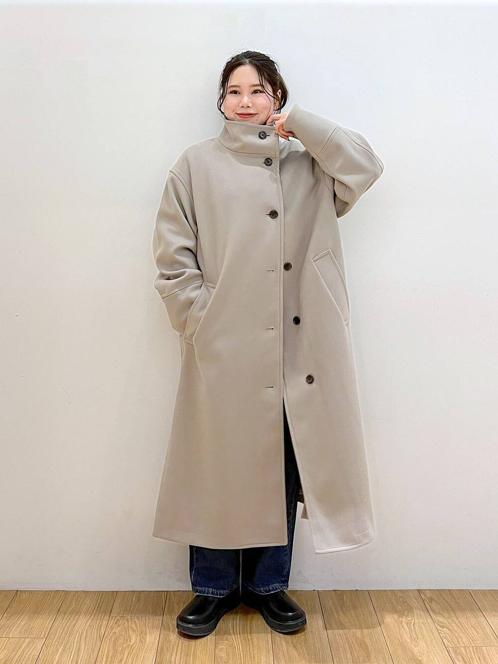 ブラウン系のチェスターコート、ブルー系のデニムパンツ、ブラック系のブーツを着用したレディースの冬コーディネートの6枚目の写真