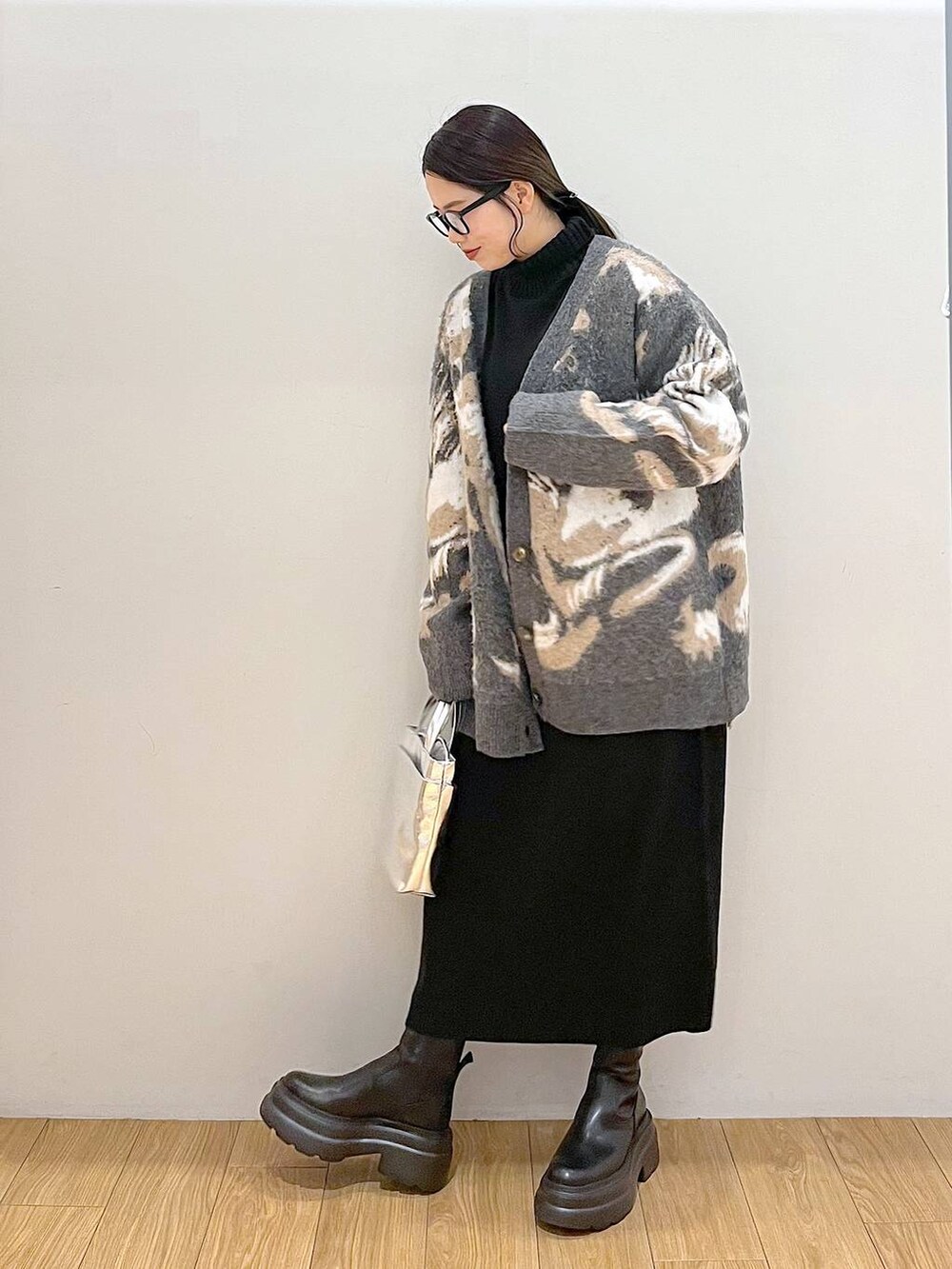 シルバー系のショルダーバッグ、ブラック系のワンピース、グレー系のカーディガン/ボレロを着用したレディースの冬コーディネートの4枚目の写真